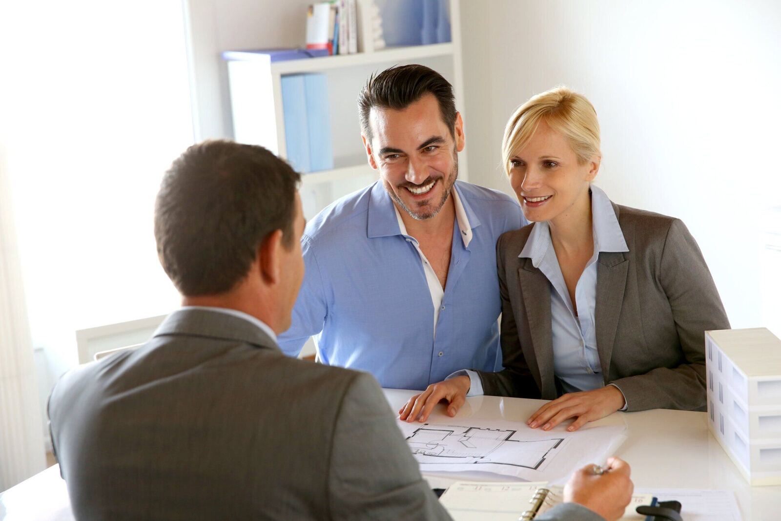 Smiling couple meeting with an attorney in a comfortable consultation